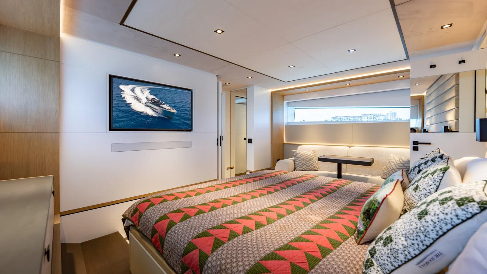 The stateroom features a spacious bed, modern decor, and a large window providing natural light. aboard RESOLUTE Yacht for Sale