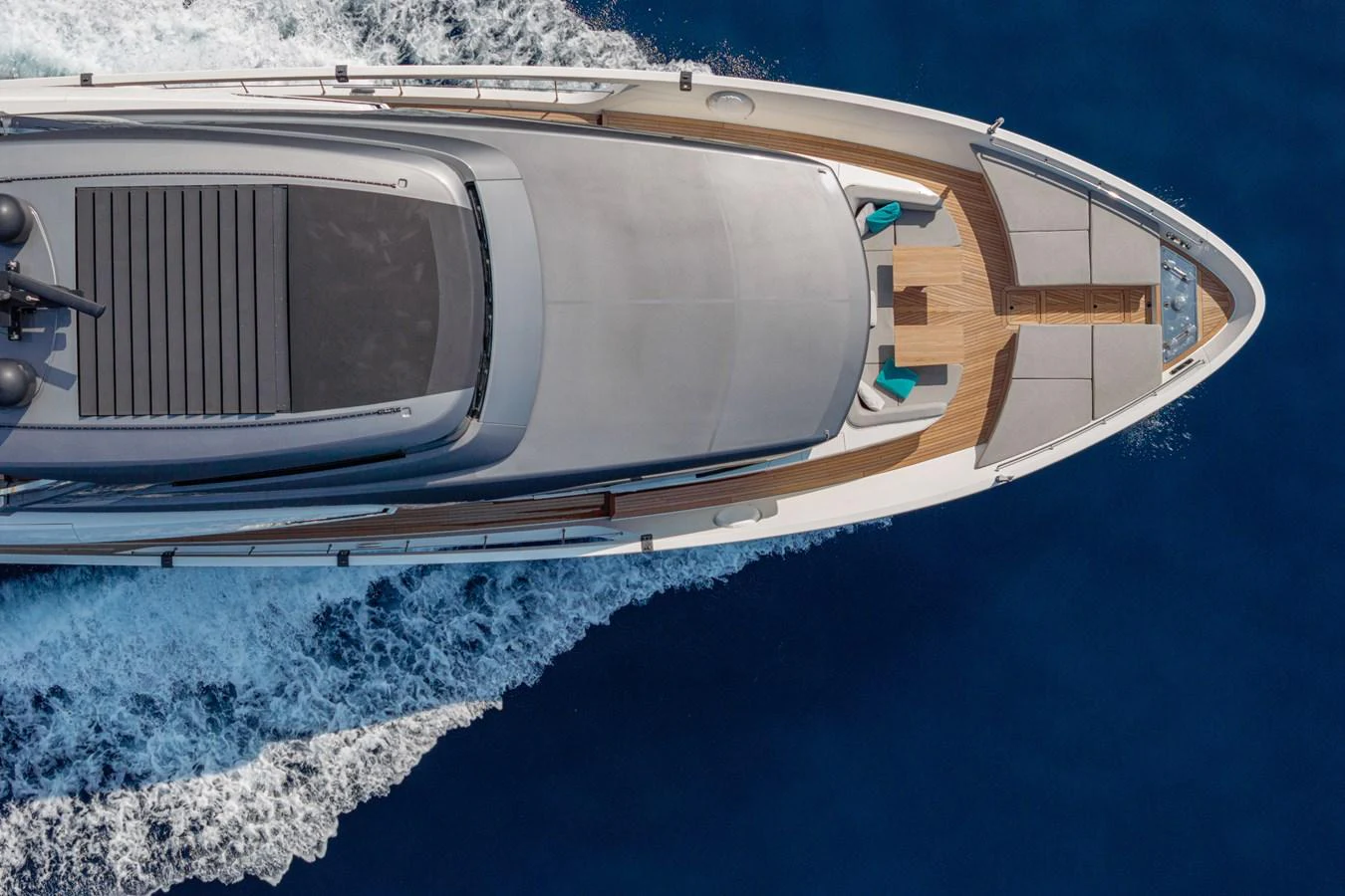The yacht glides gracefully through the water, showcasing its sleek deck and luxurious lounging area. aboard M&M Yacht for Sale