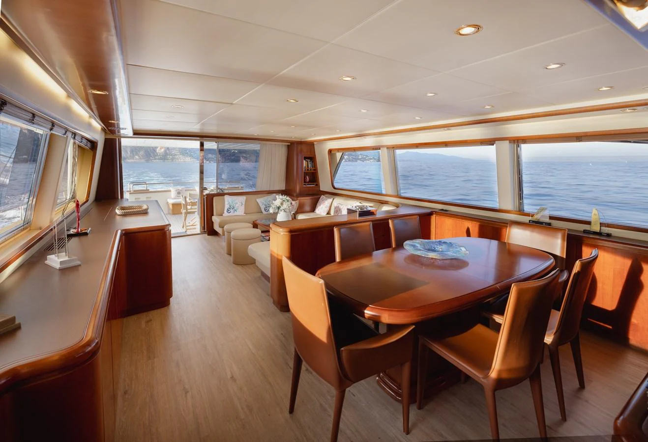 The yacht's salon features elegant wood finishes, plush seating, and expansive windows offering stunning ocean views. aboard LADY MAUREEN Yacht for Sale
