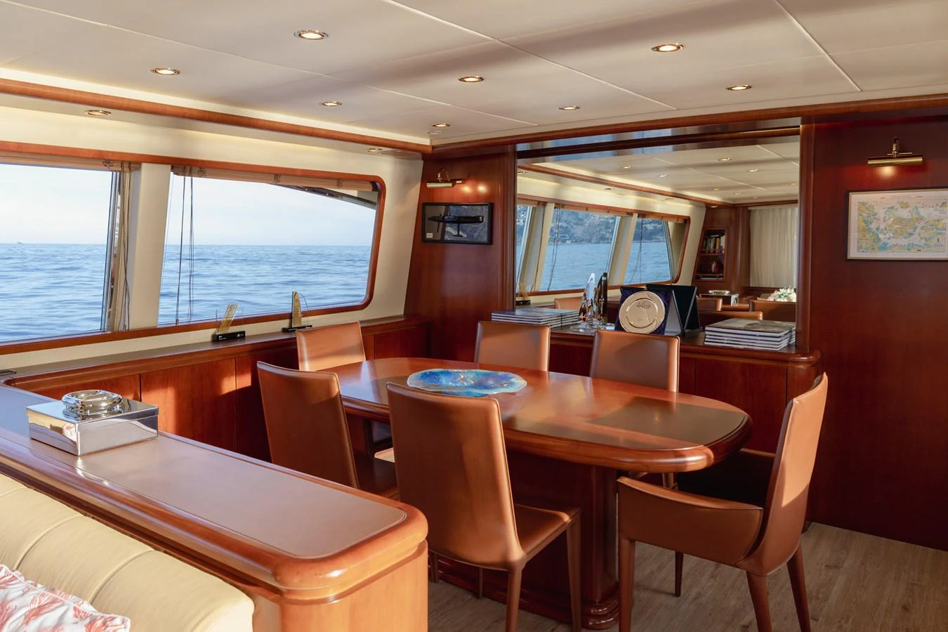 The yacht's dining area features elegant wood finishes and expansive windows with a view of the sea. aboard LADY MAUREEN Yacht for Sale