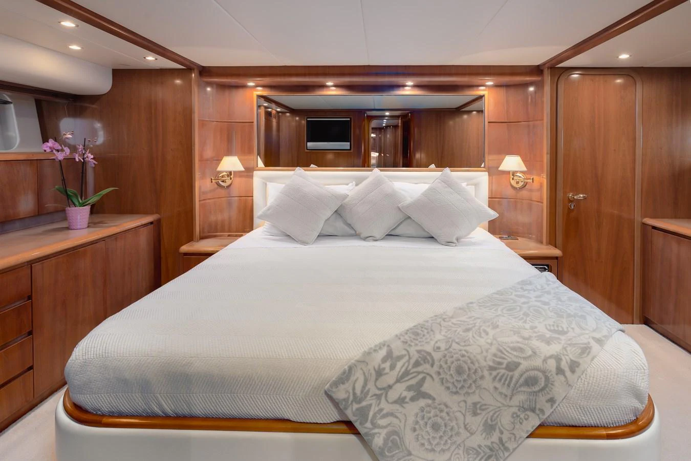 The master stateroom features a luxurious bed with elegant wood paneling and soft lighting. aboard LADY MAUREEN Yacht for Sale