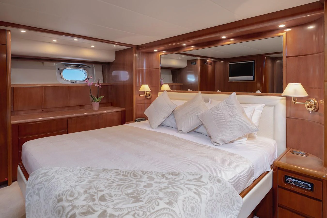 The master stateroom features a luxurious bed with elegant wood paneling and soft lighting. aboard LADY MAUREEN Yacht for Sale