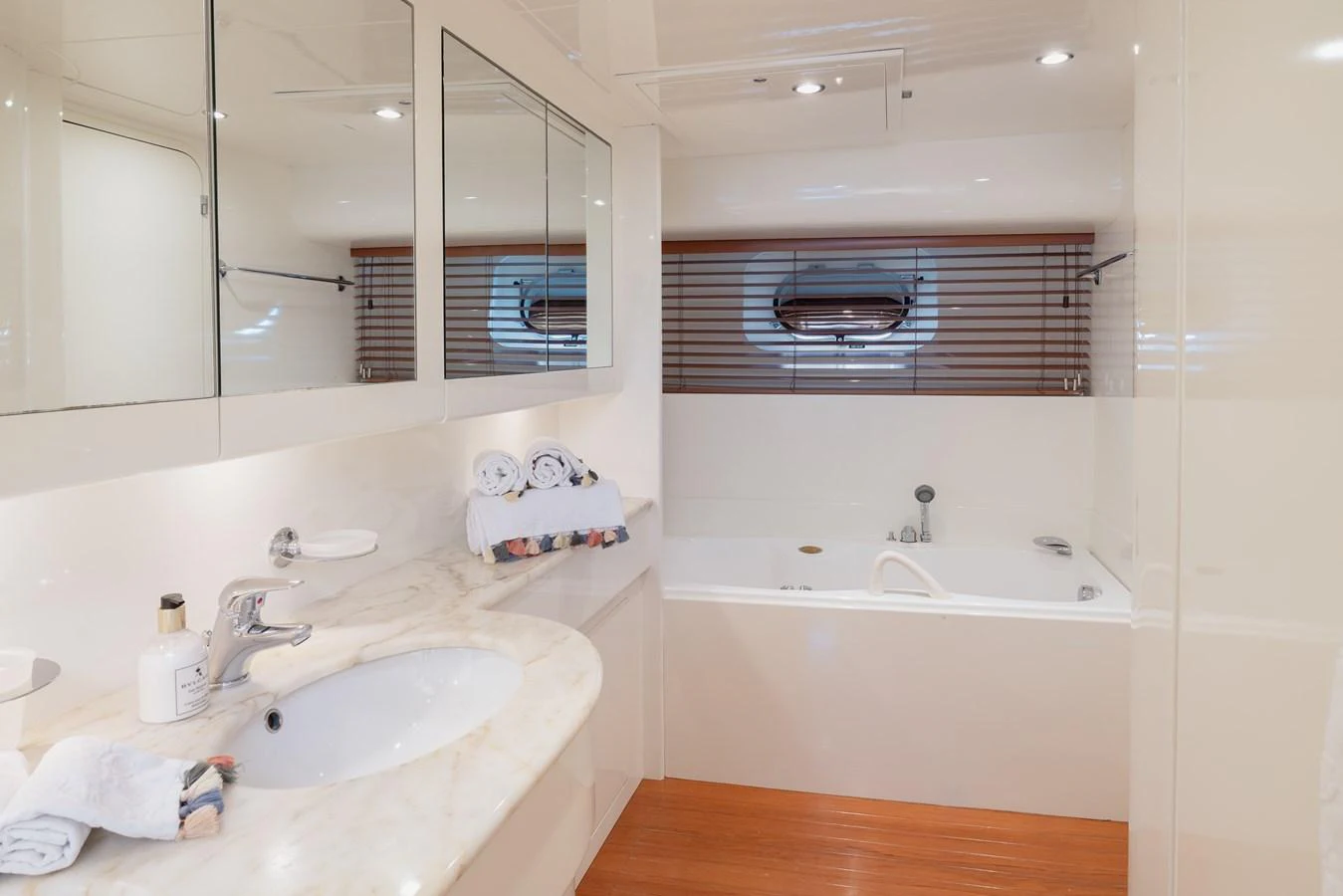 This luxurious yacht bathroom features a sleek design with a marble countertop and a spacious bathtub. aboard LADY MAUREEN Yacht for Sale