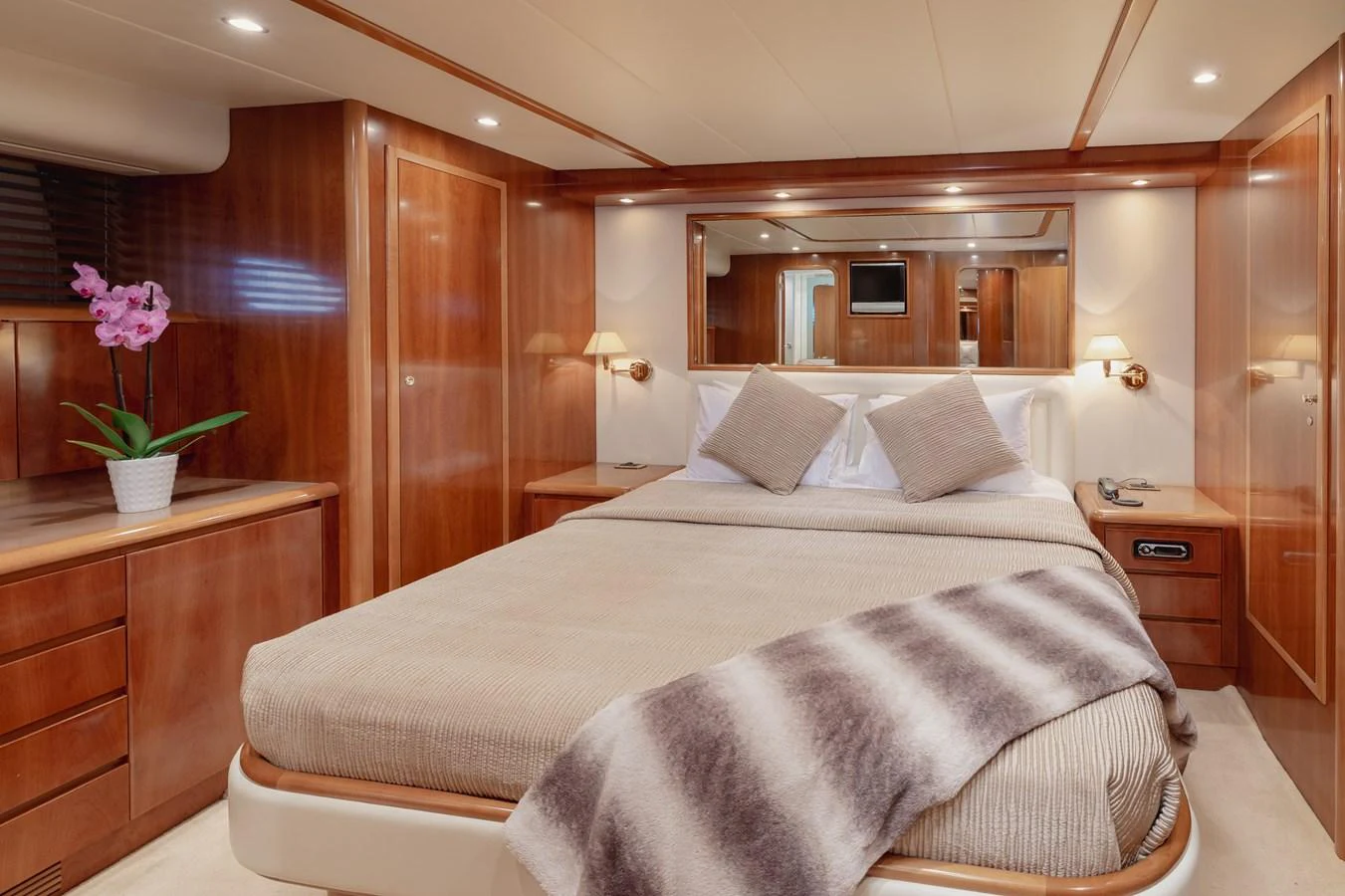 The master stateroom features a luxurious bed with plush linens and elegant wooden cabinetry. aboard LADY MAUREEN Yacht for Sale