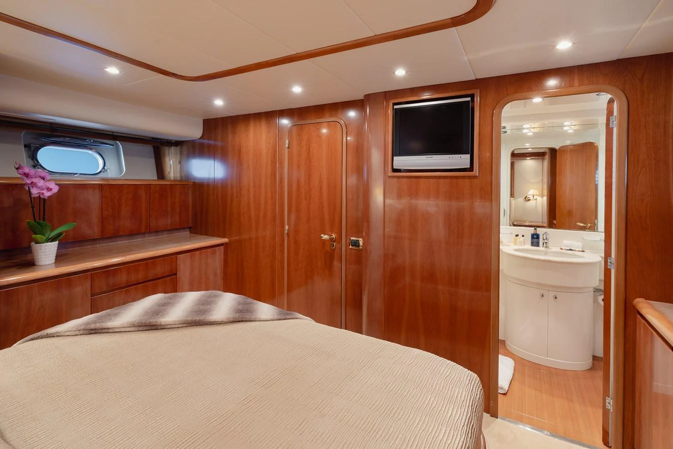 The master stateroom features elegant wood paneling, a comfortable bed, and an ensuite bathroom. aboard LADY MAUREEN Yacht for Sale
