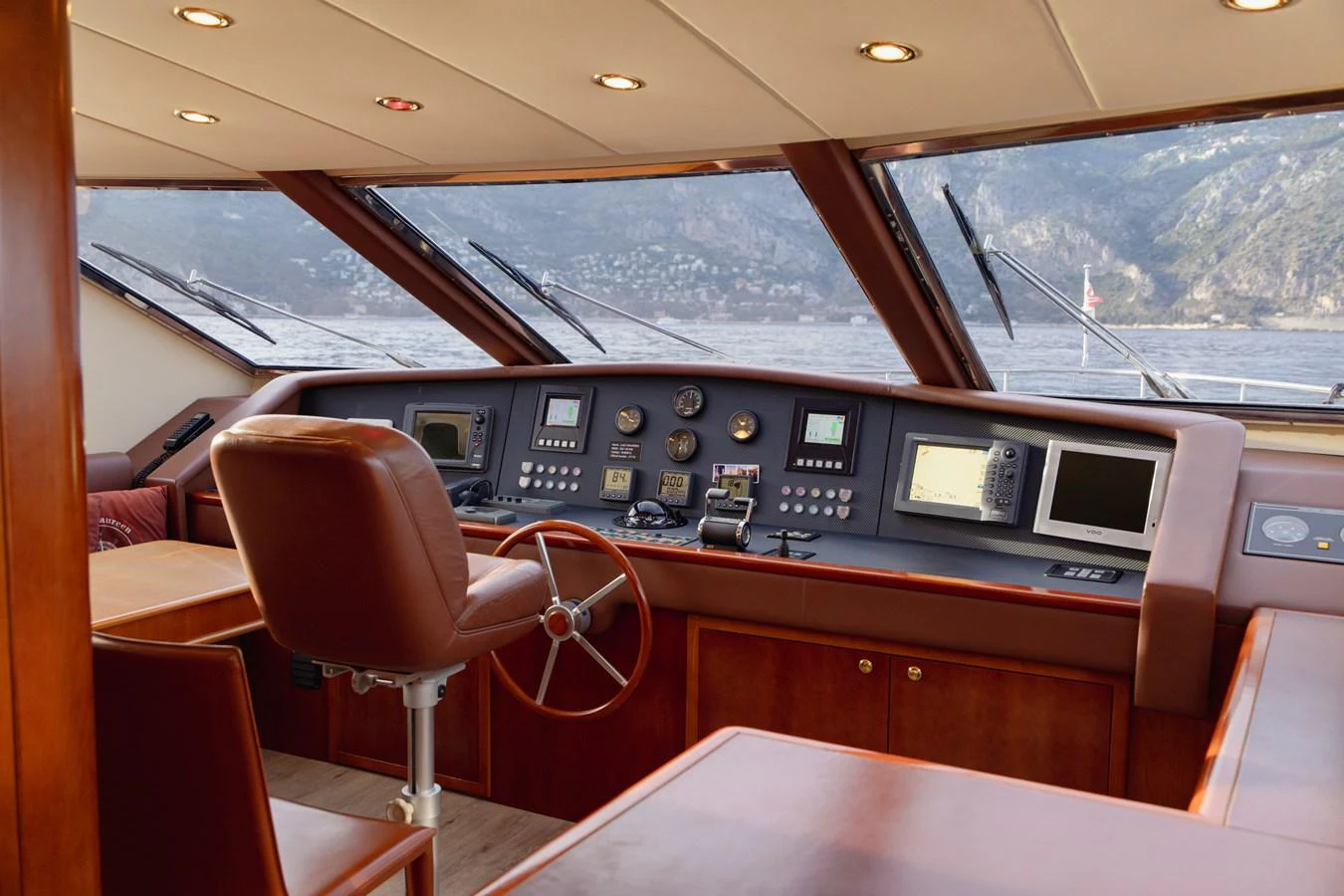 The helm station offers a commanding view with sophisticated navigation equipment and luxurious seating. aboard LADY MAUREEN Yacht for Sale