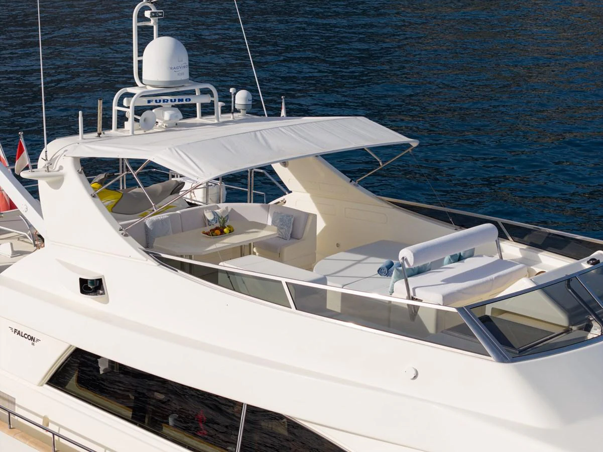 The yacht's flybridge offers a luxurious outdoor seating area with a sunshade and a dining table, perfect for relaxation and entertainment. aboard LADY MAUREEN Yacht for Sale