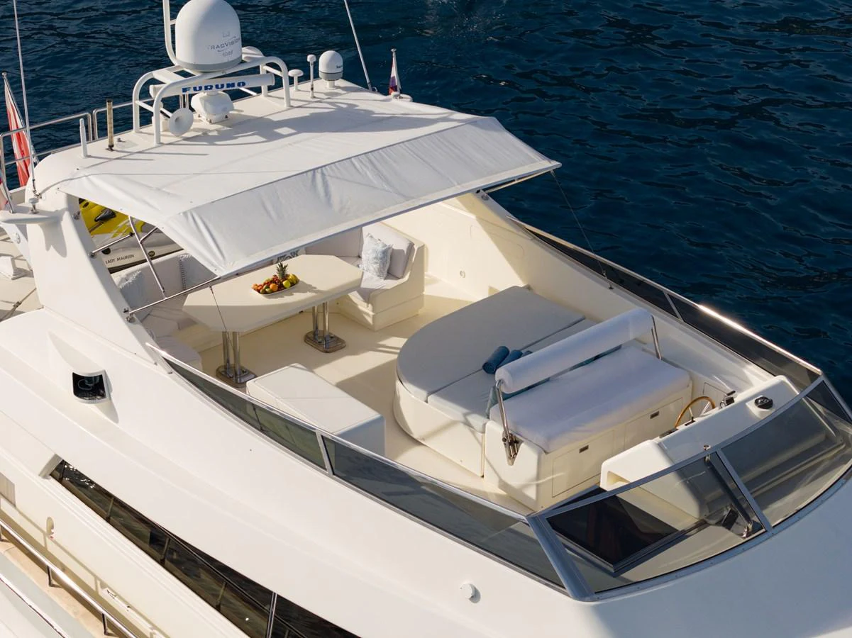 The flybridge offers a spacious and luxurious outdoor area with comfortable seating and a dining table, perfect for enjoying the sea views. aboard LADY MAUREEN Yacht for Sale