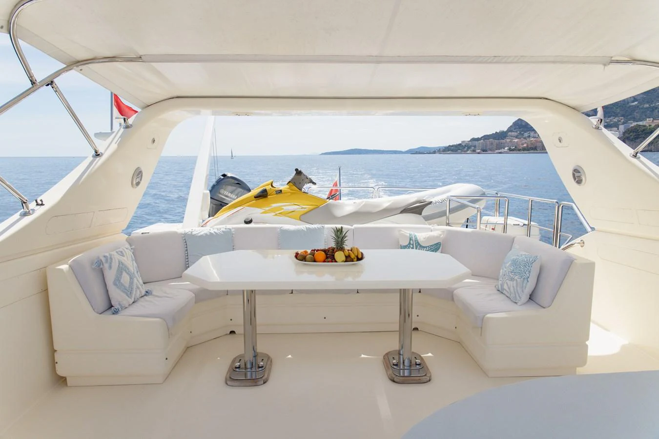 The aft deck features a spacious seating area with a central dining table, perfect for enjoying meals with a view of the sea. aboard LADY MAUREEN Yacht for Sale
