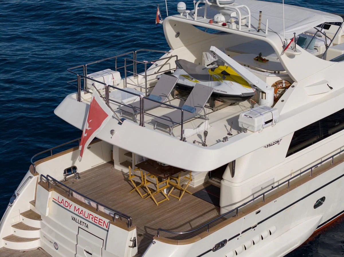 The yacht's aft deck features a spacious lounging area with sunbeds and a dining table, perfect for relaxation and entertainment. aboard LADY MAUREEN Yacht for Sale
