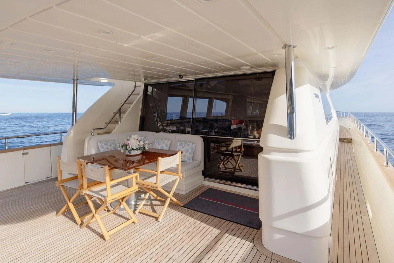 The aft deck features a comfortable seating area with a dining table, perfect for al fresco meals with a view of the sea. aboard LADY MAUREEN Yacht for Sale