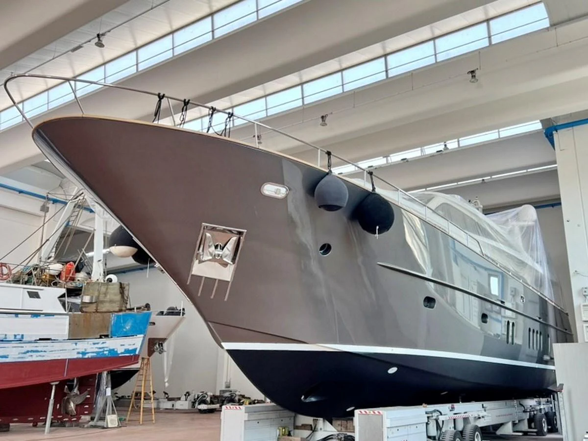 The yacht is seen in a shipyard, showcasing its sleek exterior design and modern lines. aboard NICOSTASIA Yacht for Sale