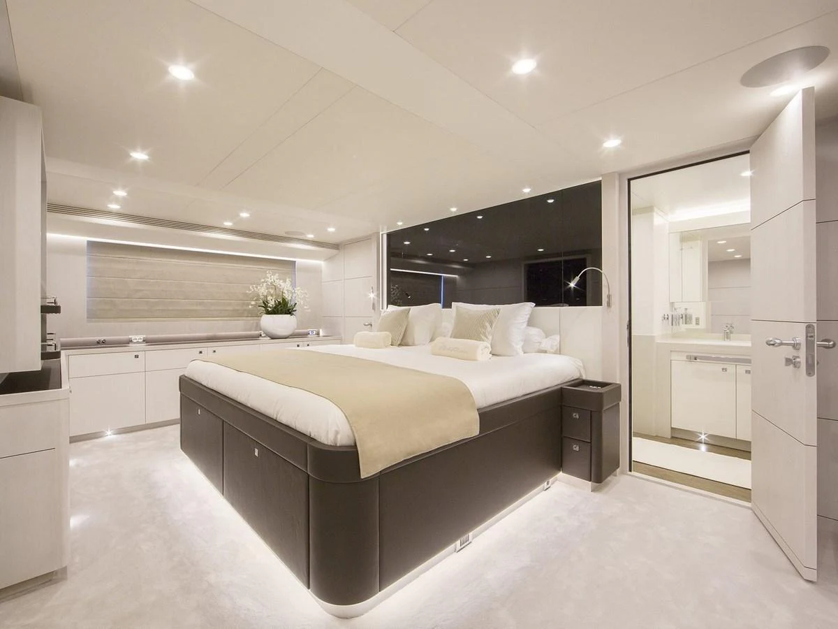 The master stateroom features a luxurious bed with elegant lighting and modern decor. aboard NICOSTASIA Yacht for Sale