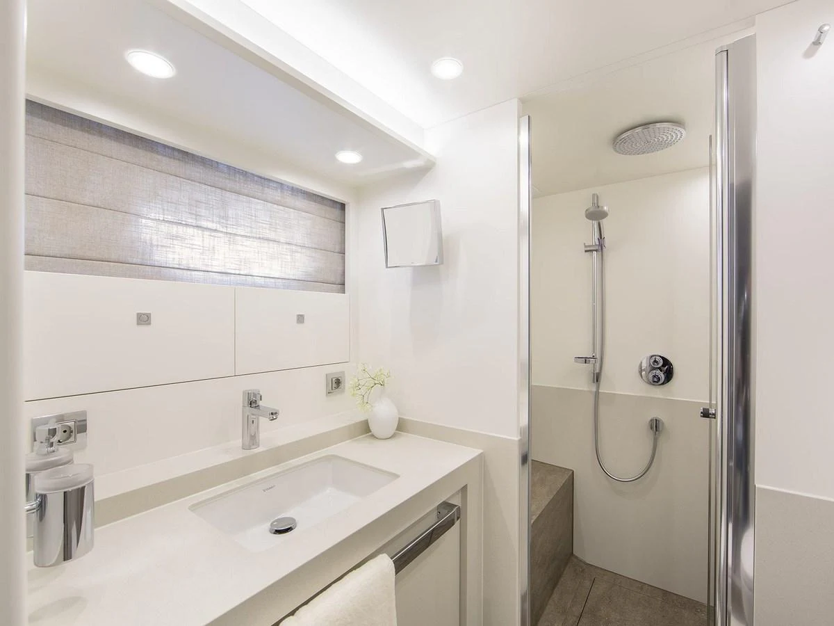 The yacht's bathroom features a sleek, modern design with a spacious shower and elegant fixtures. aboard NICOSTASIA Yacht for Sale