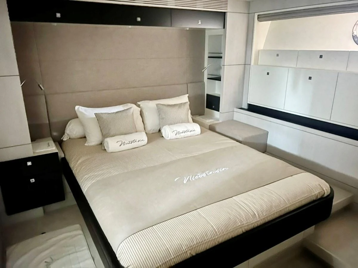 The stateroom features a luxurious bed with elegant bedding and ample storage space. aboard NICOSTASIA Yacht for Sale