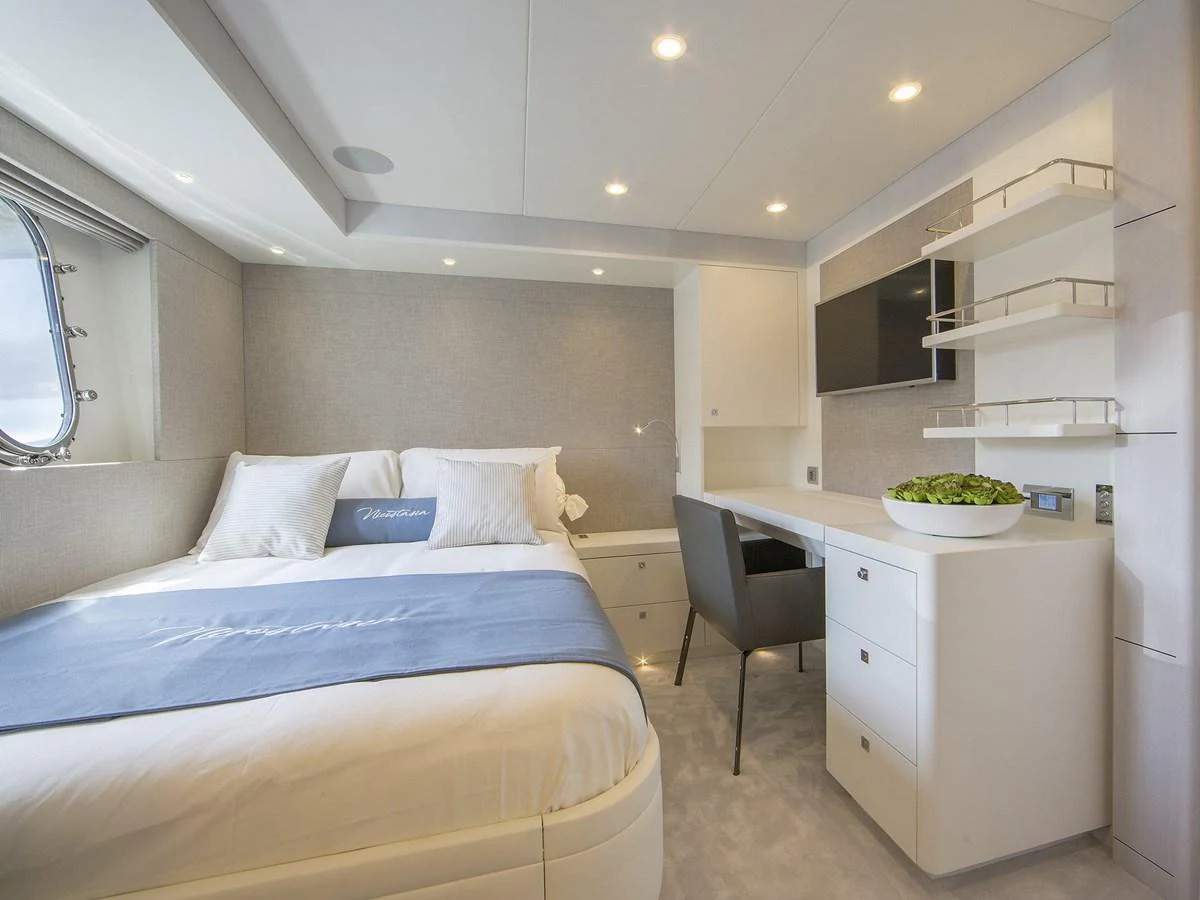 A luxurious stateroom featuring a comfortable bed, desk area, and modern decor. aboard NICOSTASIA Yacht for Sale