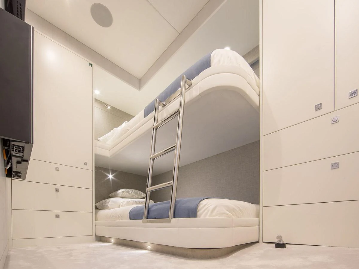 The yacht features a modern bunk room with sleek design and comfortable bedding. aboard NICOSTASIA Yacht for Sale