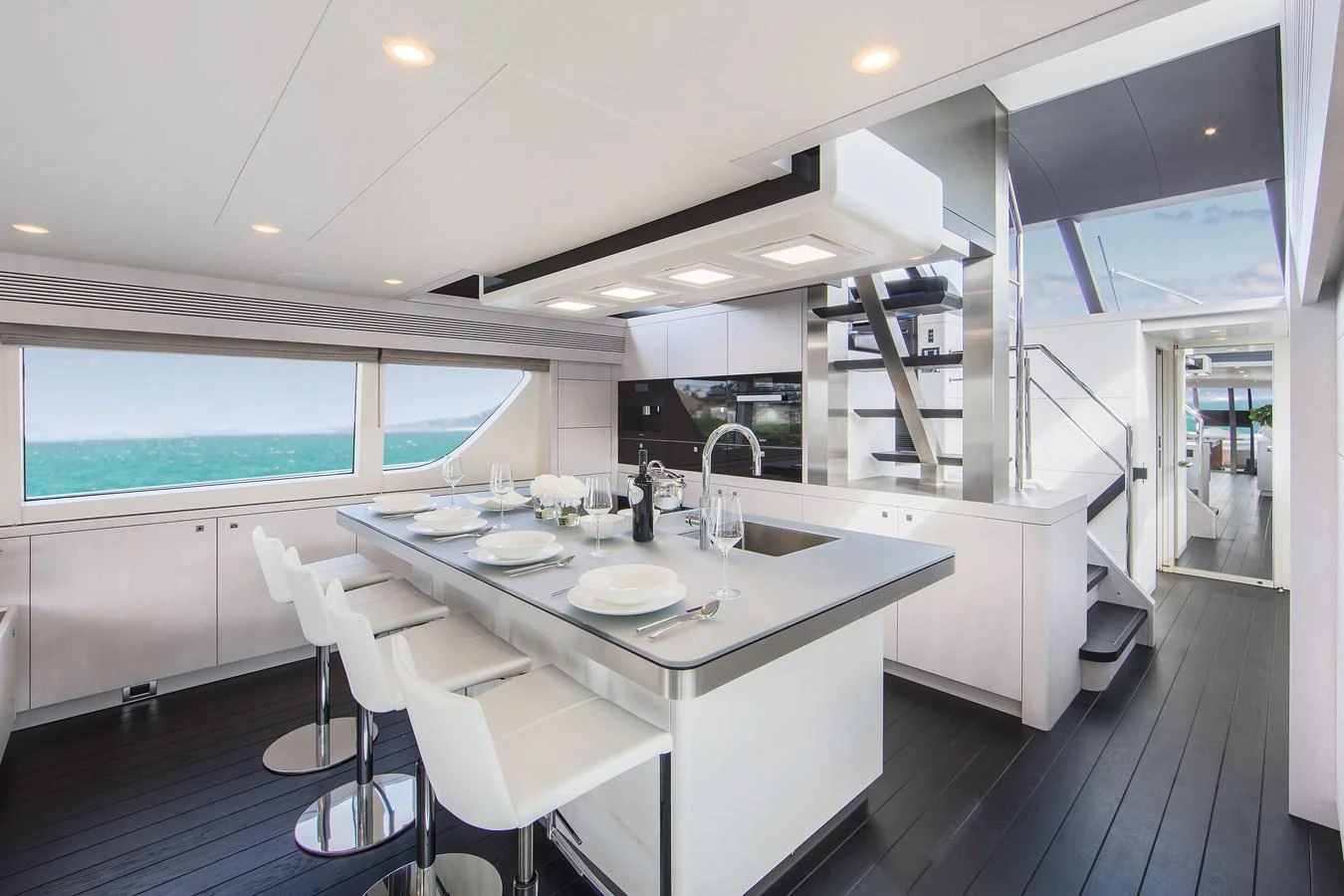 The yacht's galley features a modern design with sleek white cabinetry and a spacious dining area. aboard NICOSTASIA Yacht for Sale