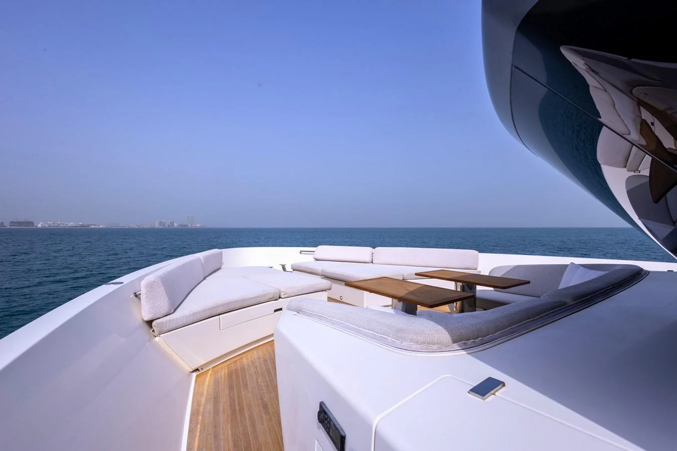 The yacht features a spacious and inviting bow seating area with plush cushions and a wooden table, perfect for relaxation and socializing while enjoying the ocean views. aboard ILIA Yacht for Sale