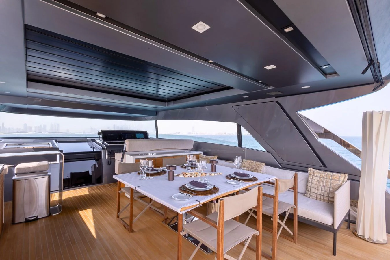The yacht's dining area features a stylish setup with a table set for a meal, surrounded by comfortable seating and modern decor. aboard ILIA Yacht for Sale