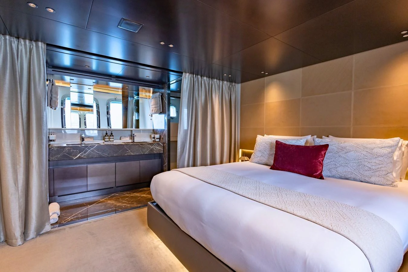 The master stateroom features a luxurious bed and an en-suite bathroom with elegant finishes. aboard ILIA Yacht for Sale
