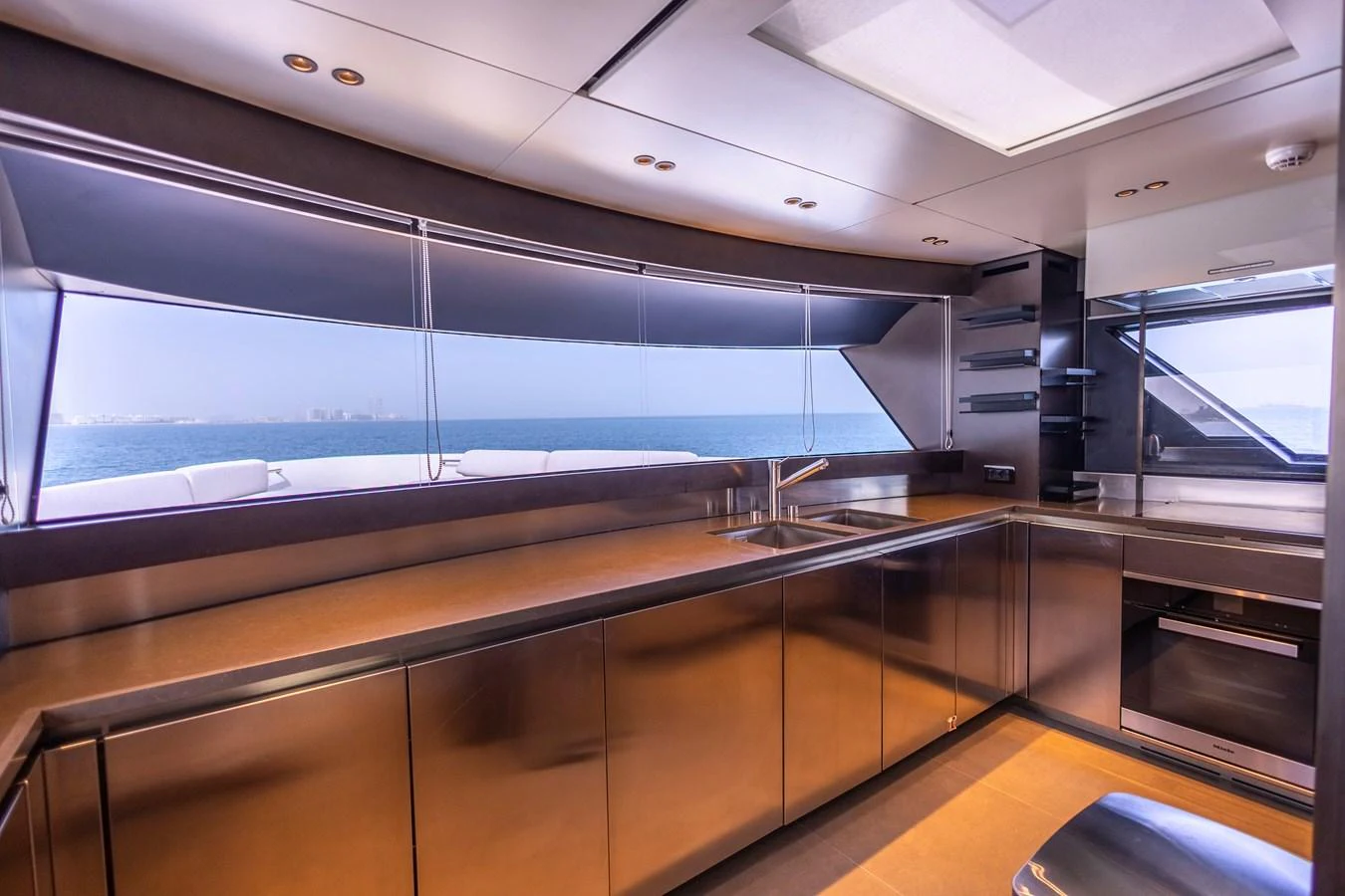 A sleek and modern galley with stainless steel appliances and panoramic ocean views. aboard ILIA Yacht for Sale