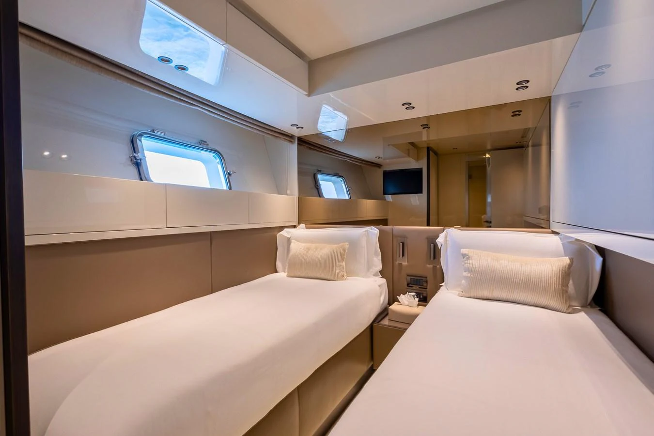The twin stateroom features two comfortable single beds with elegant bedding and ample natural light from the windows. aboard ILIA Yacht for Sale