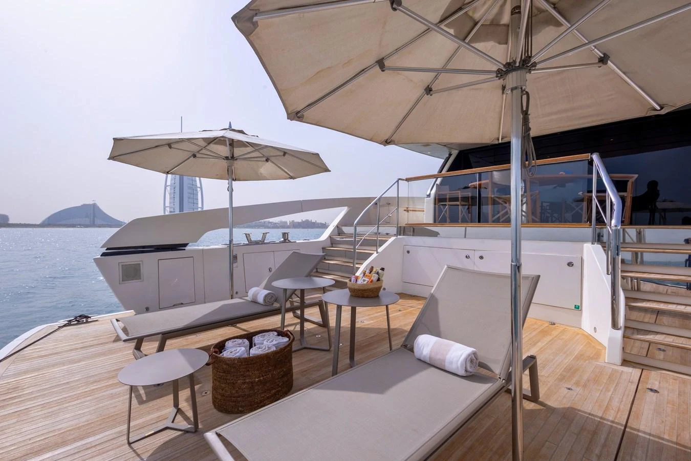 The sundeck offers a luxurious space with sun loungers, umbrellas, and a stunning view of the water. aboard ILIA Yacht for Sale