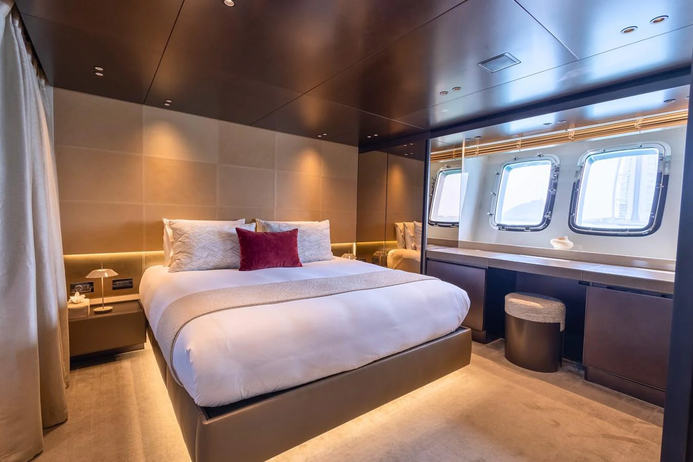 The master stateroom features a luxurious bed, ambient lighting, and large windows for natural light. aboard ILIA Yacht for Sale