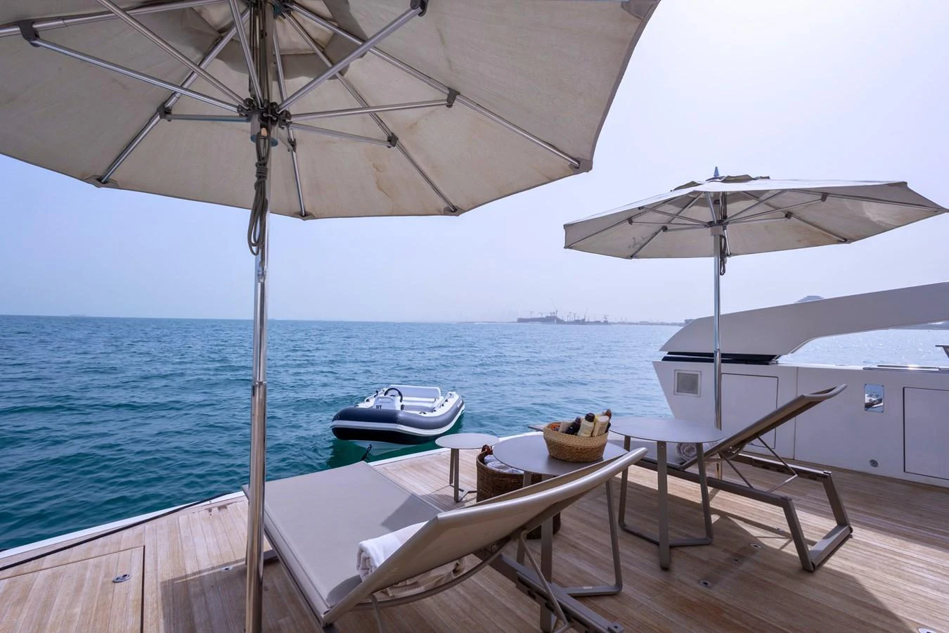 The aft deck offers a serene setting with sun loungers and parasols overlooking the calm sea. aboard ILIA Yacht for Sale