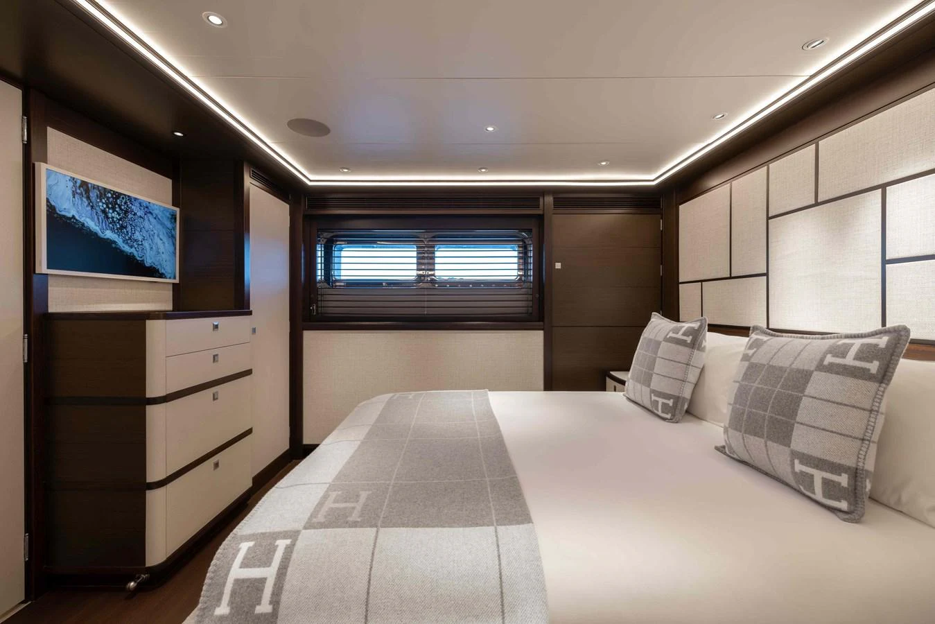 The stateroom features a luxurious bed with elegant bedding and modern decor. aboard AURA Yacht for Sale