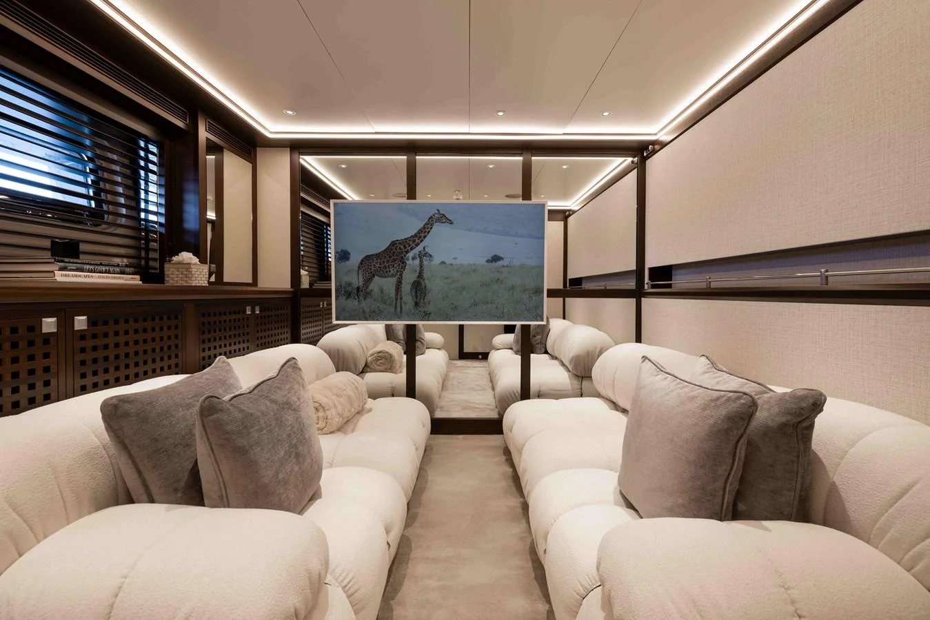 The yacht's salon features plush seating and a large screen for entertainment. aboard AURA Yacht for Sale