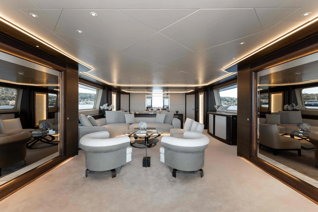 The spacious salon features elegant seating and large windows offering panoramic views. aboard AURA Yacht for Sale