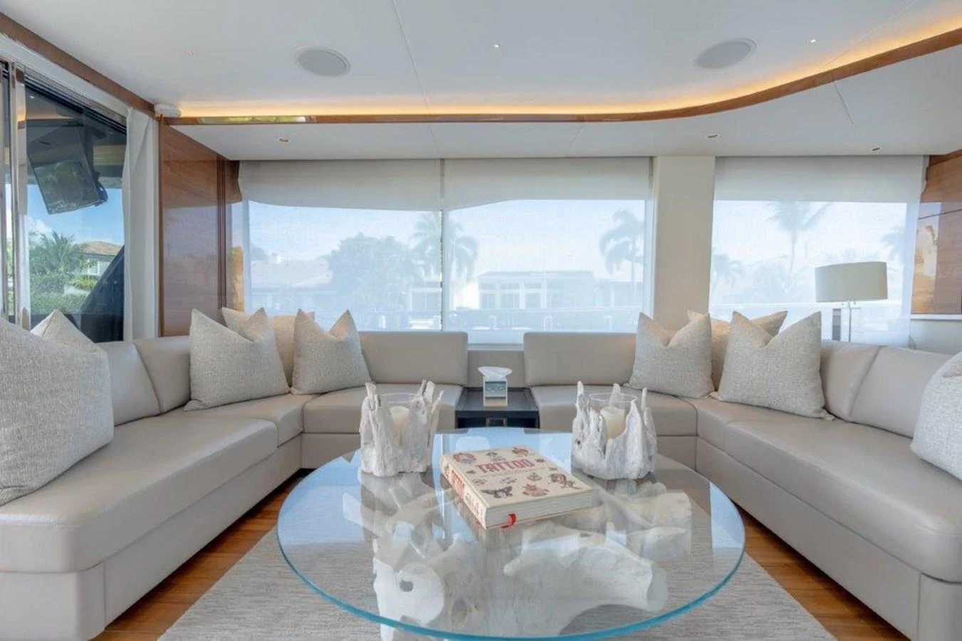 The salon features plush seating and a modern glass coffee table, creating a comfortable and stylish living space. aboard KAOS Yacht for Sale