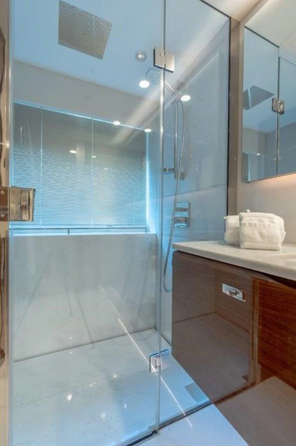A sleek and modern bathroom with a glass-enclosed shower and elegant fixtures. aboard KAOS Yacht for Sale