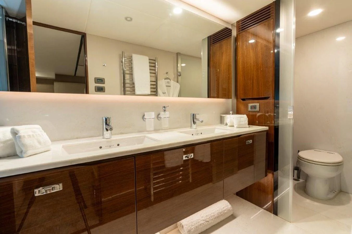 The yacht's bathroom features a sleek design with dual sinks and modern fixtures. aboard KAOS Yacht for Sale