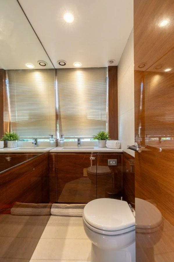 A luxurious yacht bathroom featuring sleek wooden finishes and modern fixtures. aboard KAOS Yacht for Sale