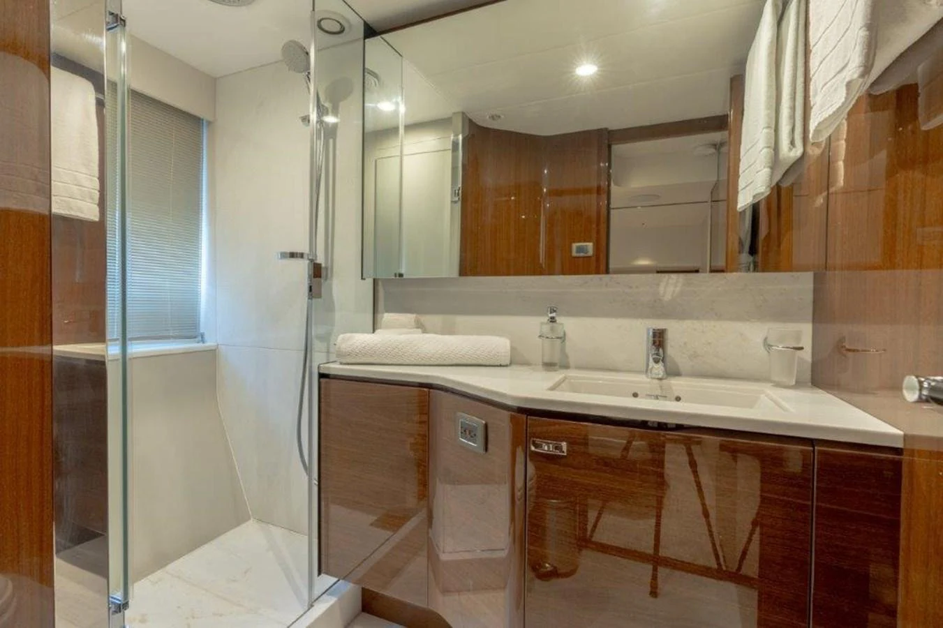 The yacht's bathroom features sleek wood finishes and modern fixtures. aboard KAOS Yacht for Sale