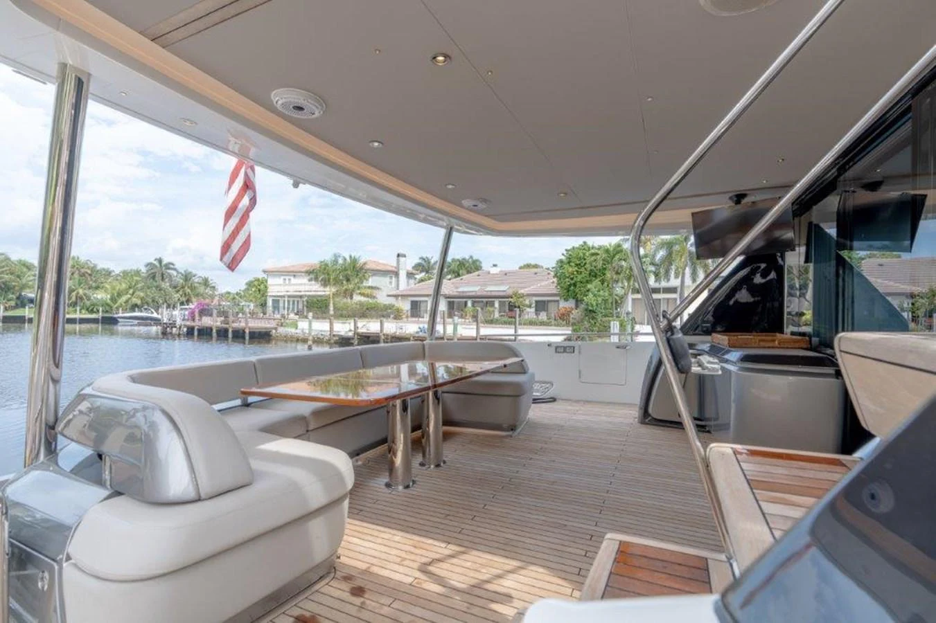The aft deck features comfortable seating and a dining area with a view of the water. aboard KAOS Yacht for Sale