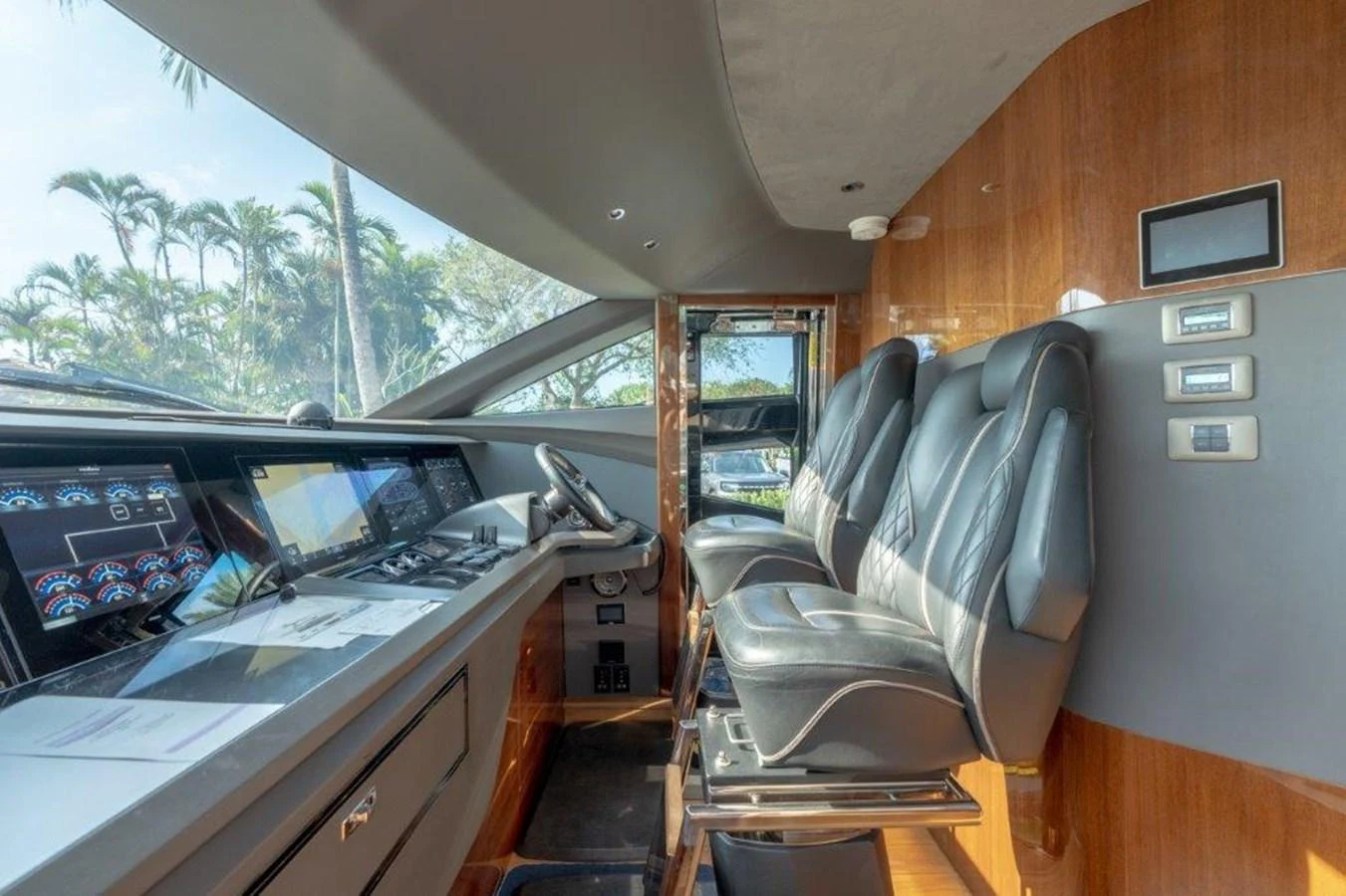The helm station features modern navigation equipment and luxurious seating with a view of the surrounding scenery. aboard KAOS Yacht for Sale