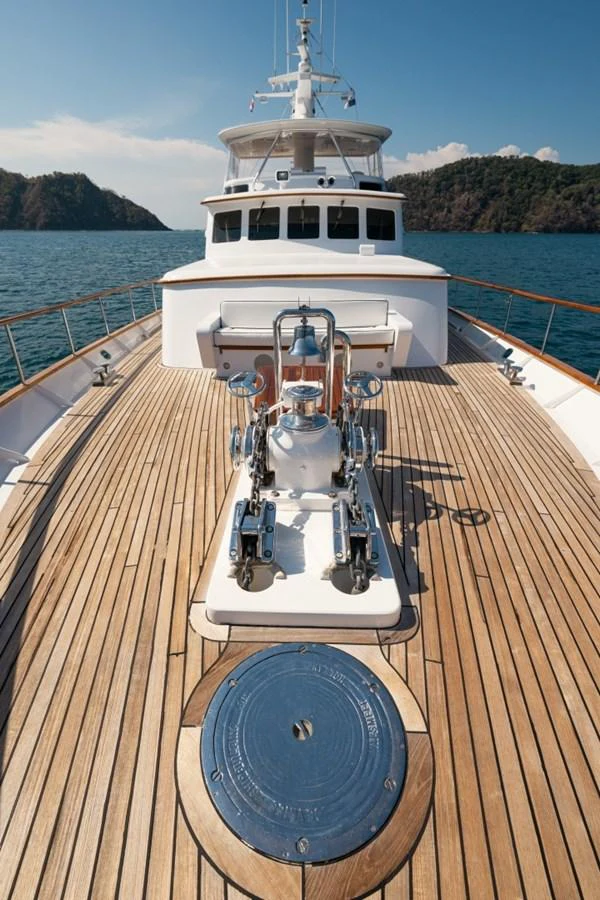 The foredeck of the yacht showcases a sleek design with polished wood and stainless steel elements. aboard PASSAGE Yacht for Sale