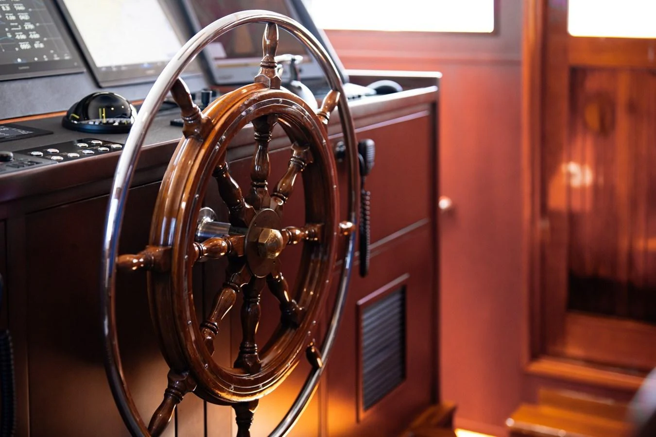 The helm station features a classic wooden steering wheel and modern navigation equipment. aboard PASSAGE Yacht for Sale