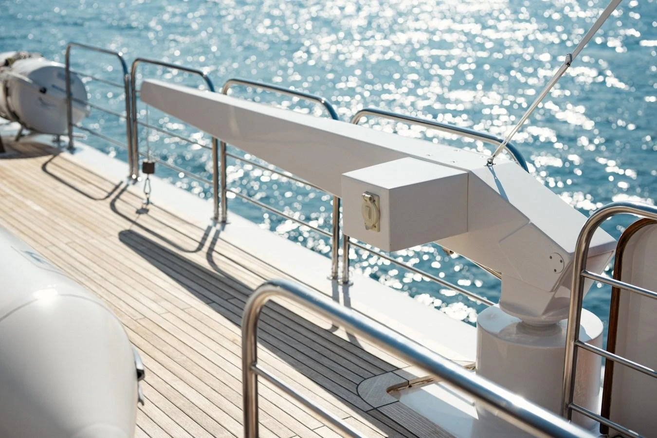 The image showcases a detailed view of the yacht's deck with a focus on the davit crane and surrounding railings. aboard PASSAGE Yacht for Sale