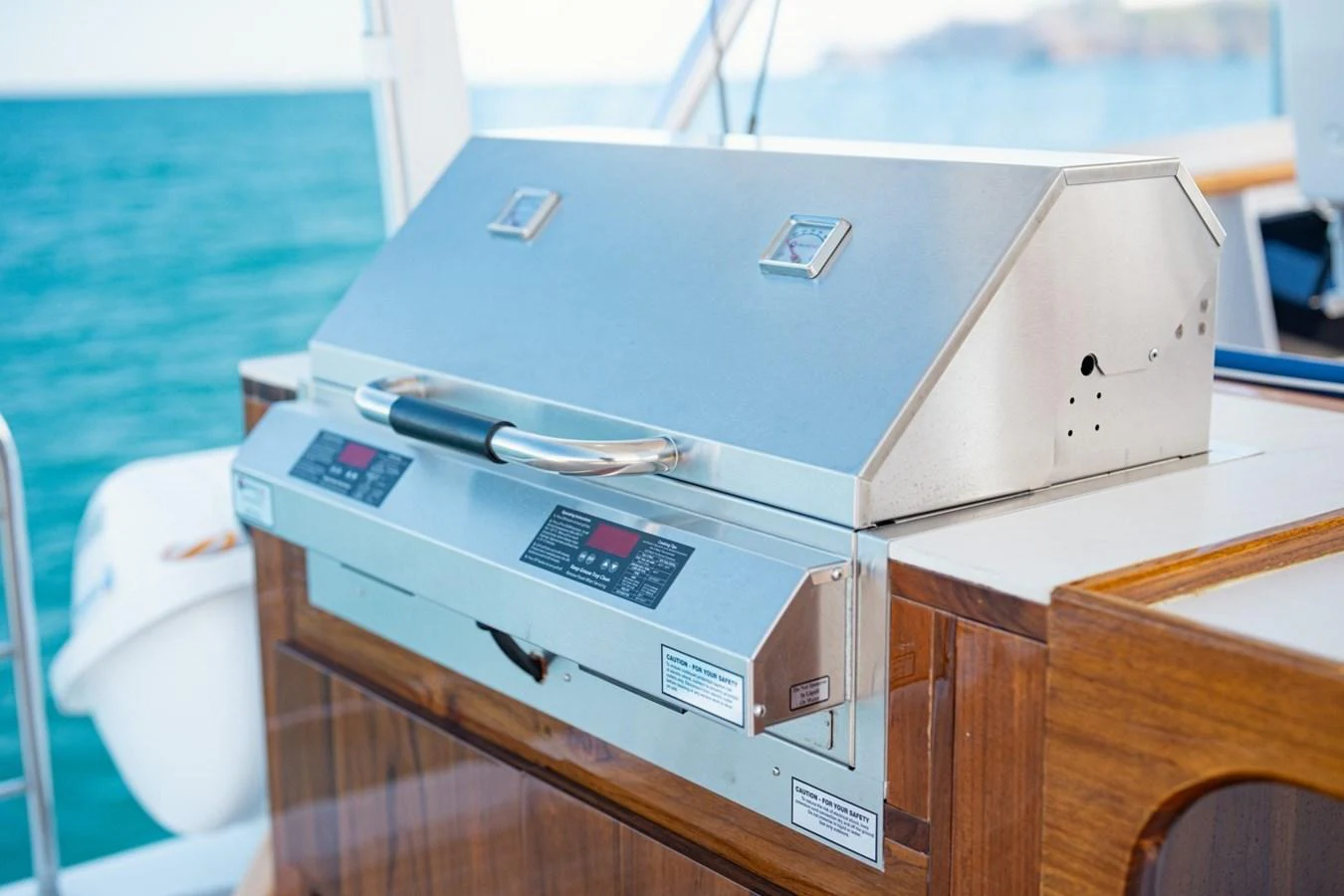 A sleek stainless steel grill is set on a polished wooden counter, ready for outdoor dining. aboard PASSAGE Yacht for Sale