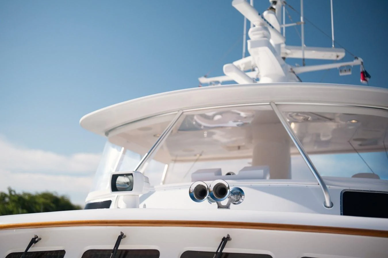A close-up view of the yacht's upper deck and navigation equipment under a clear blue sky. aboard PASSAGE Yacht for Sale
