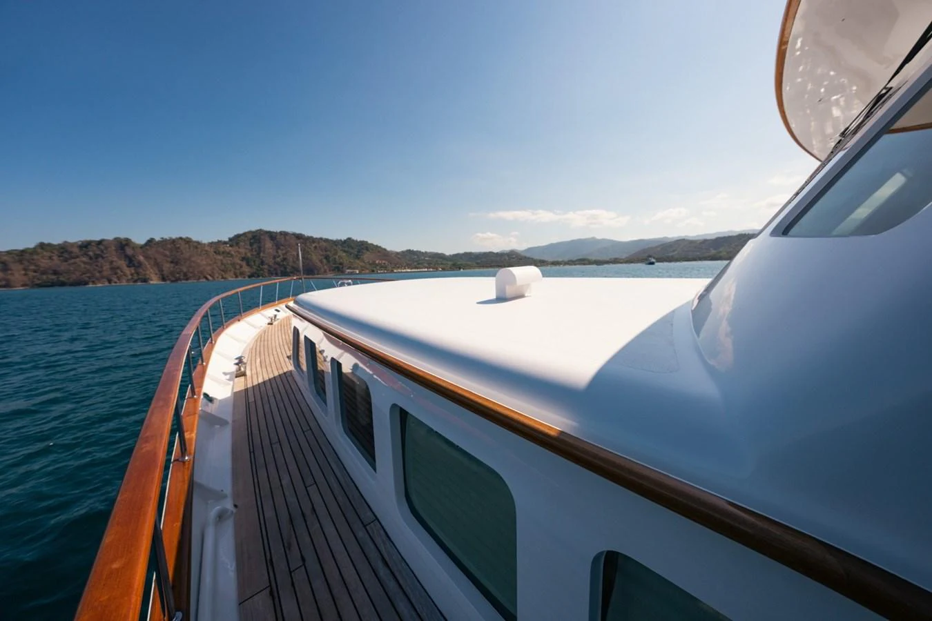 The yacht's deck offers a serene view of the surrounding waters and distant coastline. aboard PASSAGE Yacht for Sale