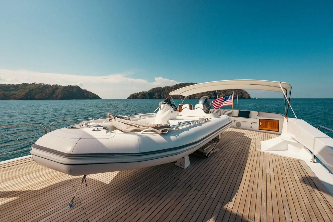 The aft deck features a spacious layout with a tender and a beautiful view of the surrounding waters. aboard PASSAGE Yacht for Sale