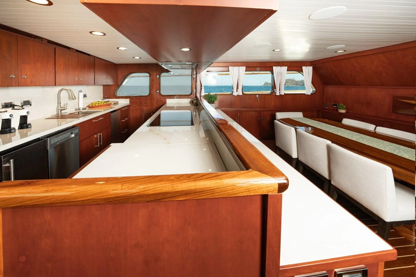 The yacht's galley features a spacious layout with modern appliances and a dining area with a view. aboard PASSAGE Yacht for Sale