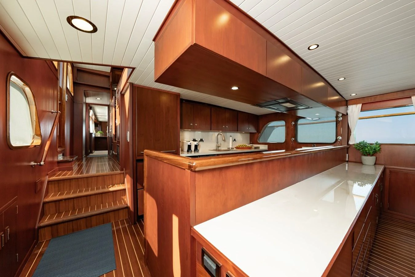 The yacht's galley features elegant wood cabinetry and modern appliances, creating a warm and inviting atmosphere. aboard PASSAGE Yacht for Sale