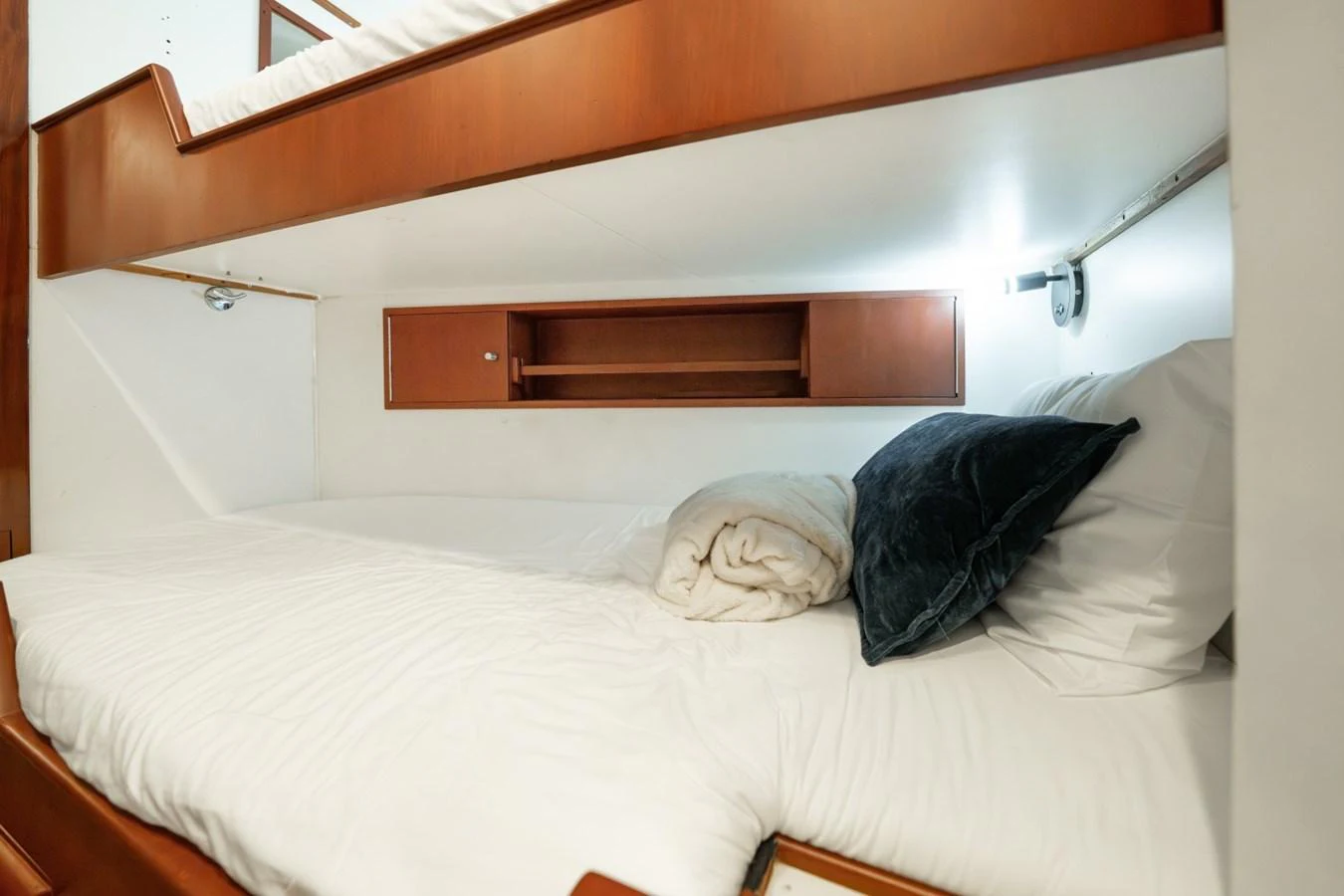 The cozy bunk cabin features neatly arranged bedding and warm wooden accents. aboard PASSAGE Yacht for Sale